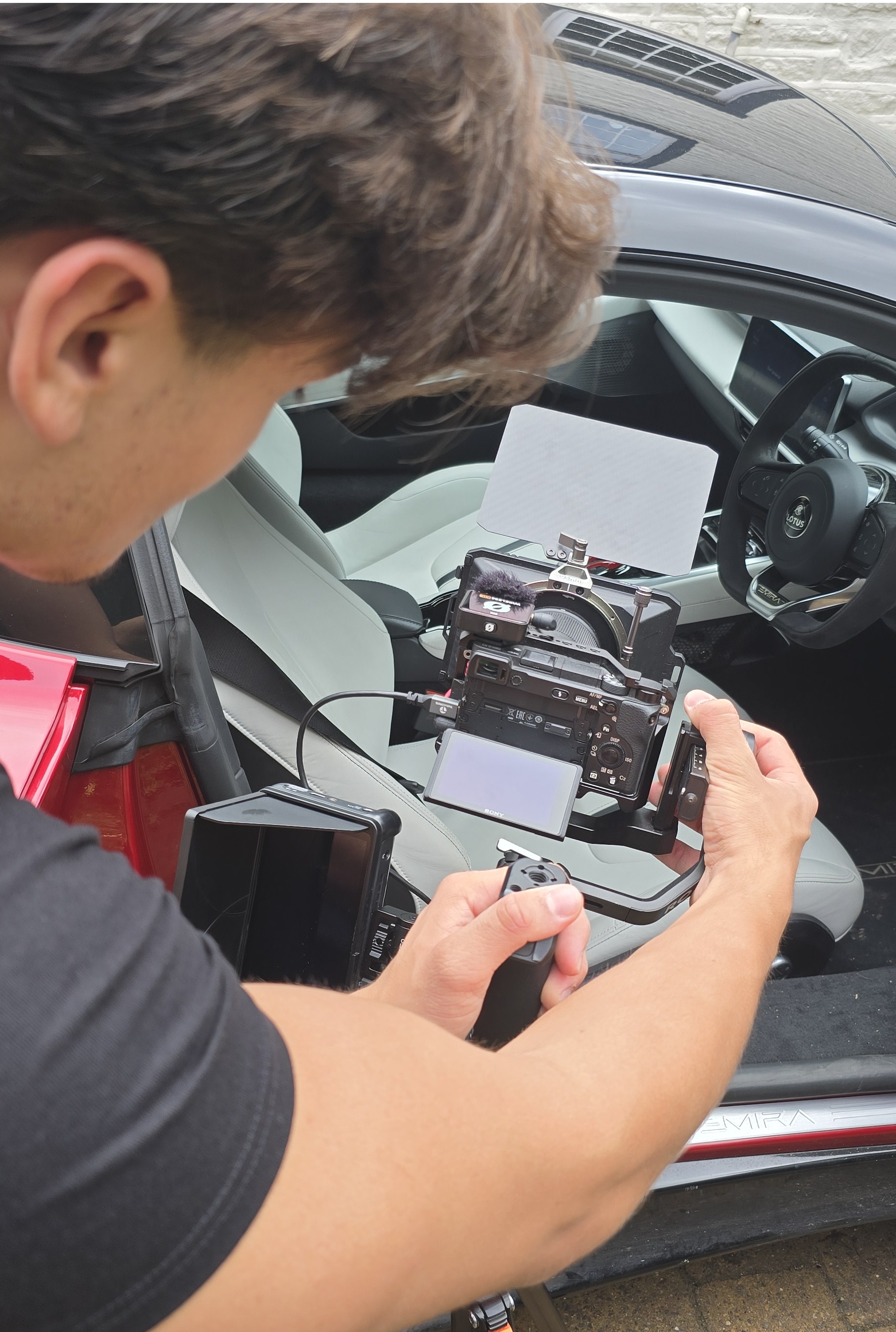 Maximum Impact videographer rigging a camera inside a Lotus for a promotional shoot